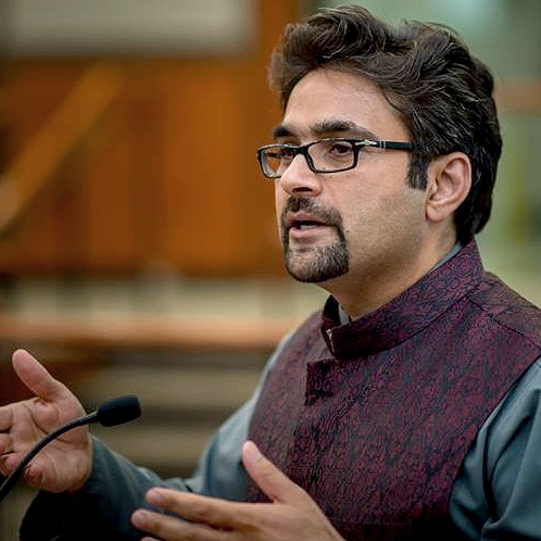 Photo of Shahid Iqbal in front of a microphone